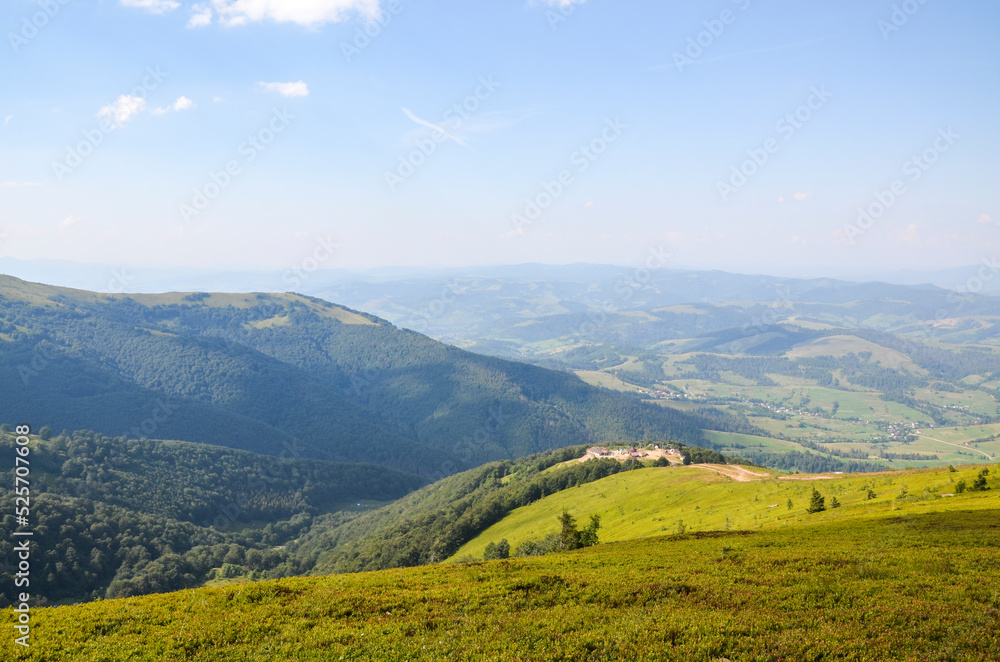 Descent from the Borzhava mountain range with a picturesque view of the valley and the village of Pylypets. Carpathians, Ukraine