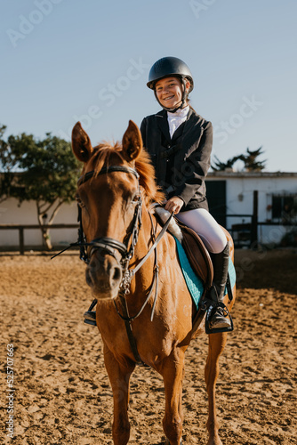 vertical portrait of a 15-year-old girl with brackets riding a horse before competition © Samuel Perales