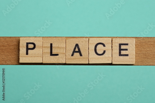 word place made of small gray wooden letters on a green paper background photo