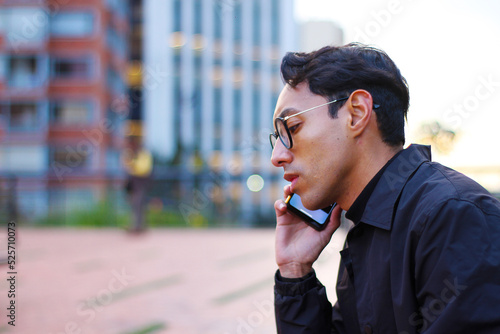 Obraz na plátne serious and concerned young man using his smart phone texting and talking to som