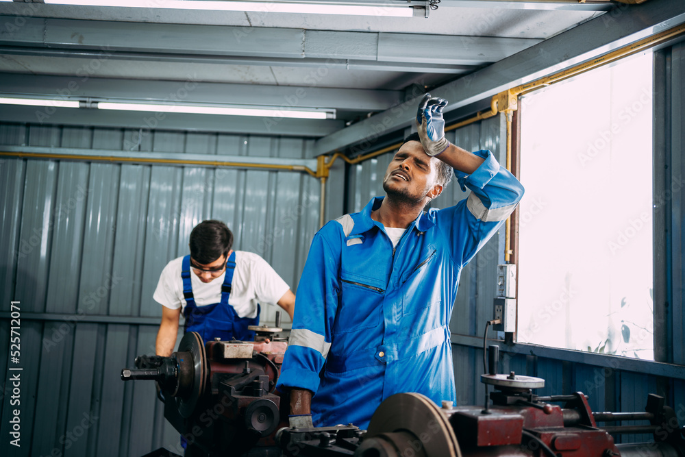 Mechanic repairman feeling tired while working with a grinding machine in the garage, weak, hopeless, burned out, Fired Unemployed Feeling Stressed. Mechanic repairman feeling tired while working with a grinding machine in the garage, weak, hopeless, burned out, Fired Unemployed Feeling Stressed.