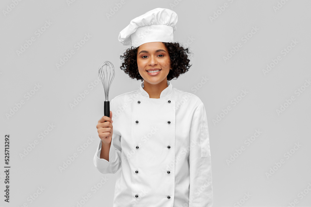 cooking, culinary and people concept - happy smiling female chef in toque with whisk over grey background