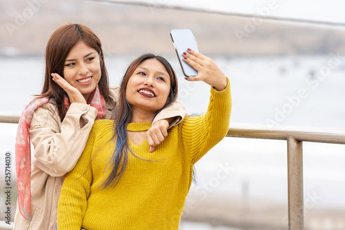 Two friends posing while taking a selfie outdoors