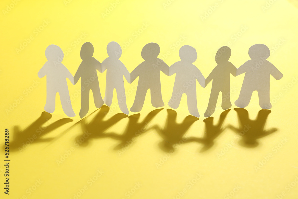 Paper people chain on yellow background. Unity concept Paper people chain on yellow background. Unity concept