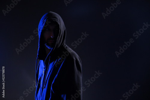 Man in hood on dark background, space for text. Cyber crime