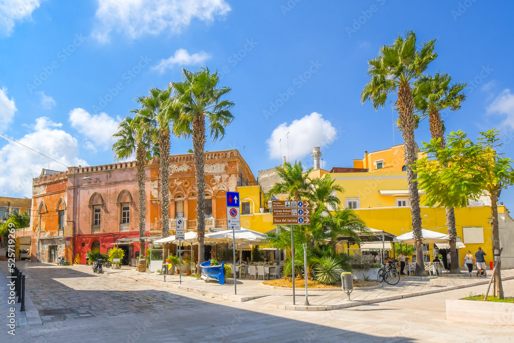 The waterfront promenade at the port of Brindisi, Italy, with colorful shops, cafes and palm trees along the Mediterranean Sea in the Puglia region.