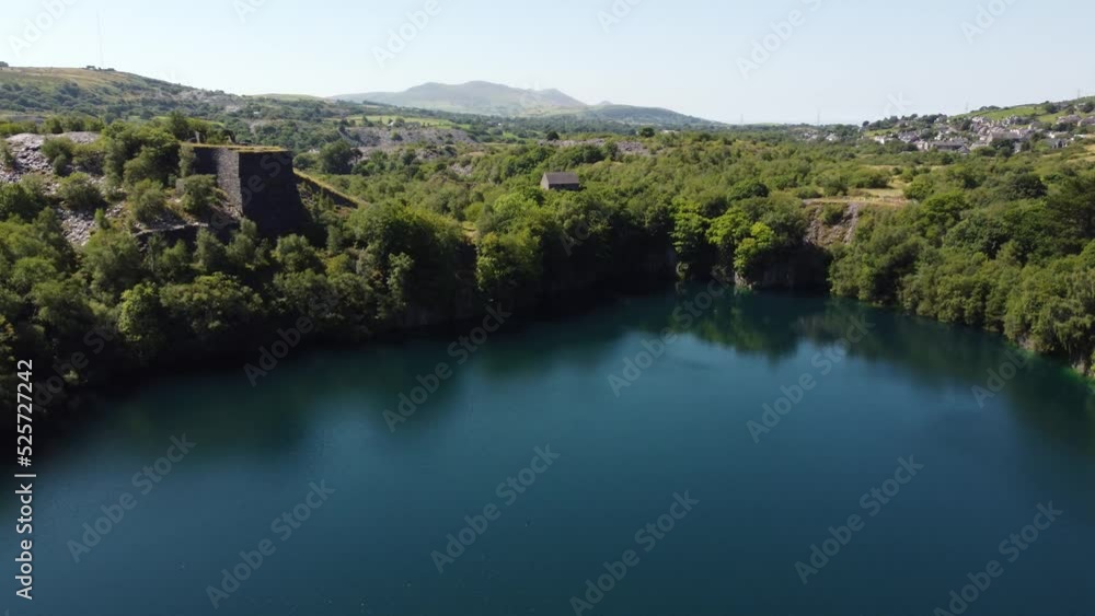 Aerial descent view Welsh woodland valley slate mining shaft and quarry lake under Snowdonia mountains Aerial descent view Welsh woodland valley slate mining shaft and quarry lake under Snowdonia mountains