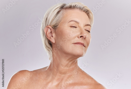 Beauty  skincare and face of a senior woman posing with closed eyes and topless against grey studio background. Happy old  elderly or mature female with glowing skin due to cosmetic self care
