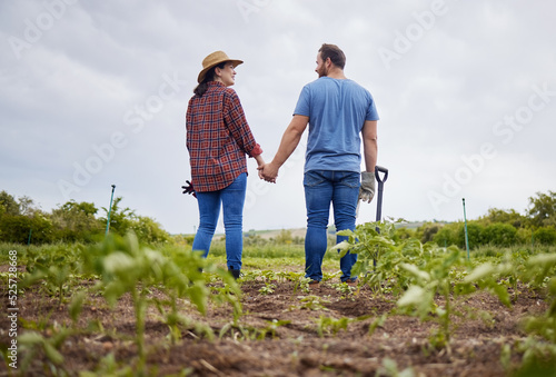 Farmer couple happy about agriculture growth with vegetable crops or plants in aorganic or sustainability farm or garden. Man and woman in nature love and enjoying outdoor and having fun together