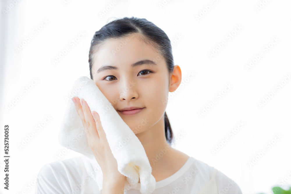 タオルで顔を拭く若い女性 タオルで顔を拭く若い女性