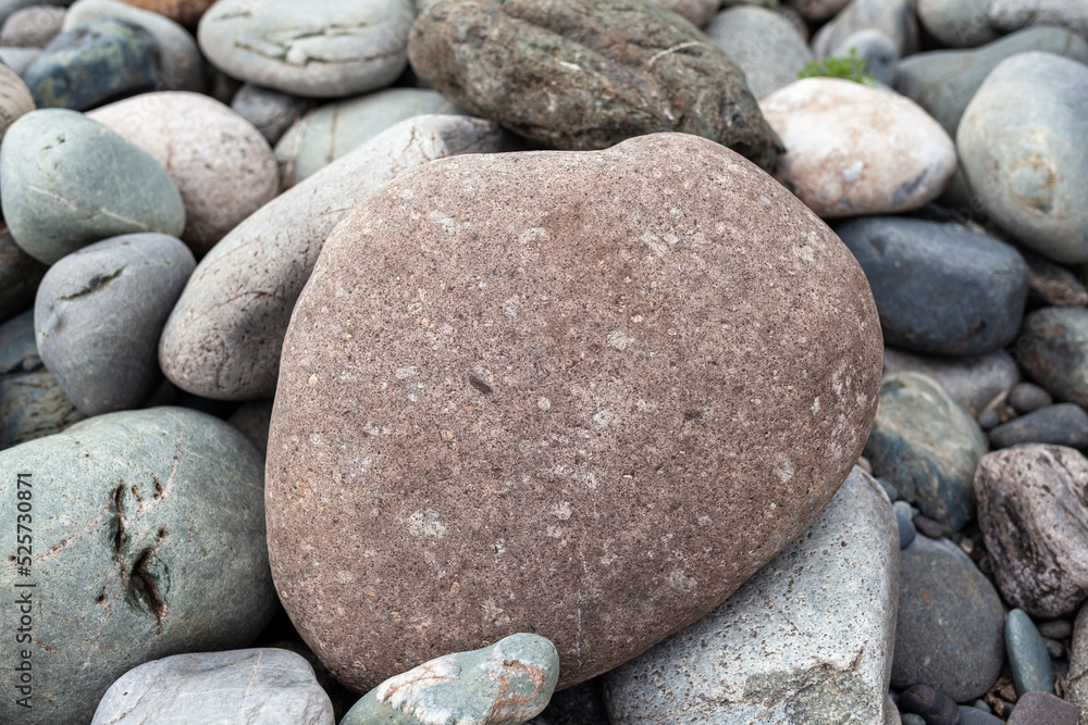 Large stones of different shapes on the riverbank close-up. there are a lot of small stones nearby. Large stones of different shapes on the riverbank close-up. there are a lot of small stones nearby.