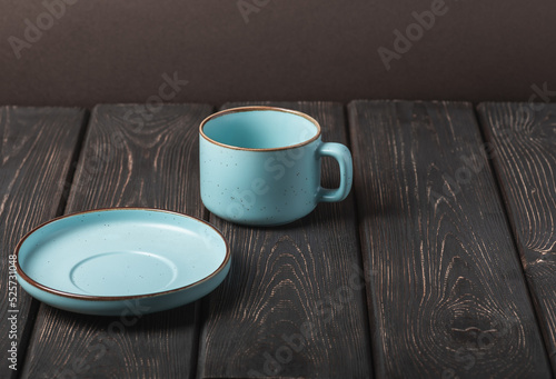 Blue cup and saucer on a dark wooden table.