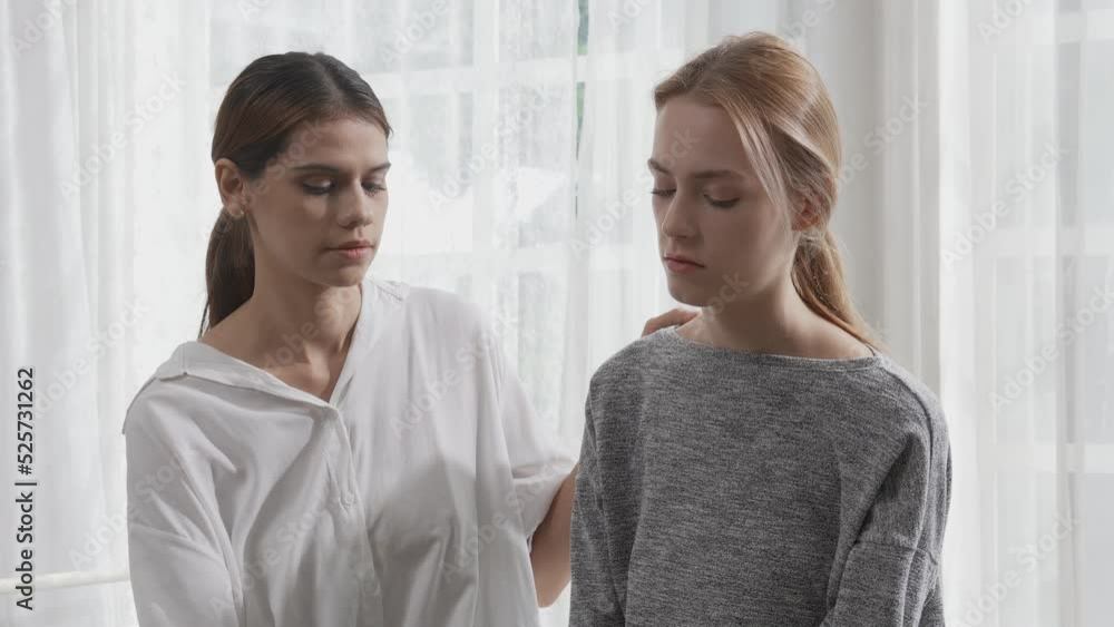 Young caucasian woman depressed while friends encourage in the bedroom at home, relation and assistance with cheering while unhappy and worried, lifestyles and feeling emotion with consoling concept. Young caucasian woman depressed while friends encourage in the bedroom at home, relation and assistance with cheering while unhappy and worried, lifestyles and feeling emotion with consoling concept.