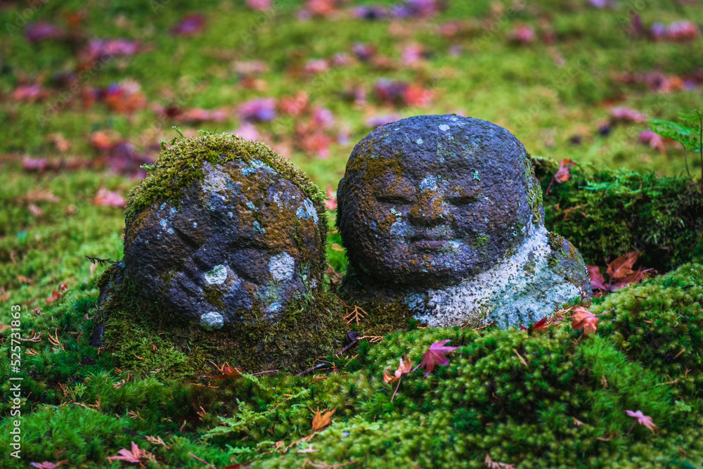 Jizo statues covered with moss. Jizo statues are intended to commemorate stillborn, miscarried or aborted children, or children who died very young.