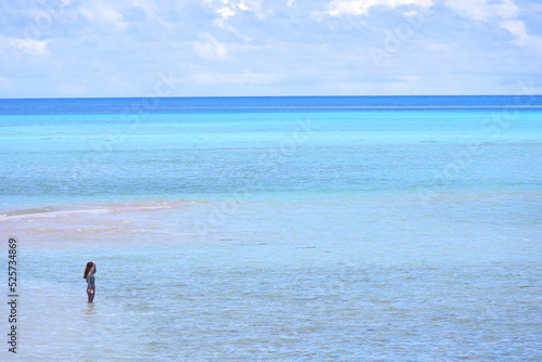 遠浅の海に立つ女の人