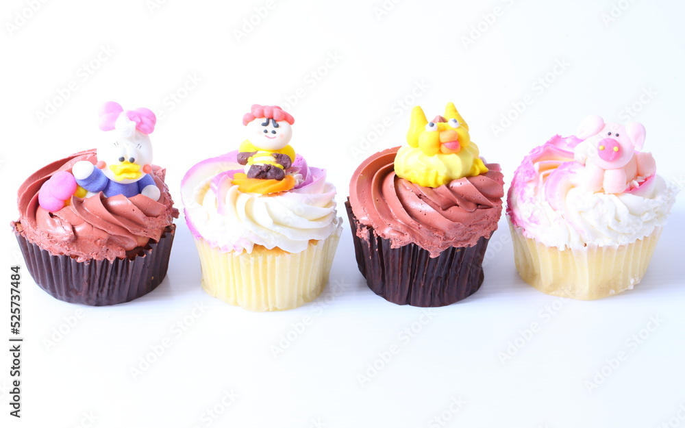 A colorful cupcake with doll on top , isolated