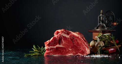 Quadro su tela Raw beef meat with rosemary, garlic, salt, and pepper.