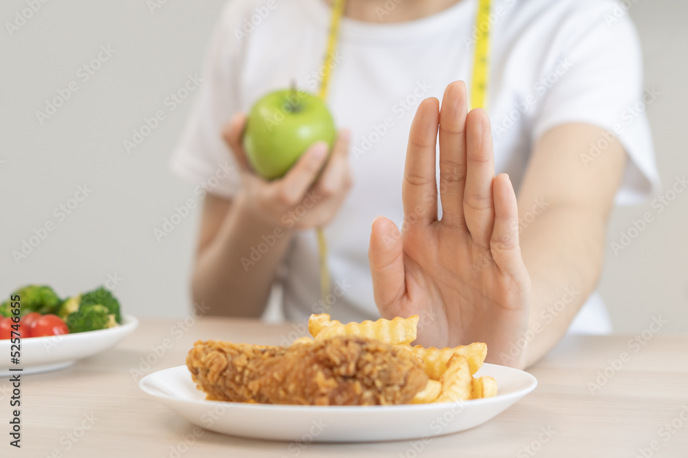 Diet, Dieting asian young woman hand in push out, deny fried chicken, french fried and choose green apple, vegetables salad, eat food for good healthy, health when hungry. Female weight loss people. Diet, Dieting asian young woman hand in push out, deny fried chicken, french fried and choose green apple, vegetables salad, eat food for good healthy, health when hungry. Female weight loss people.