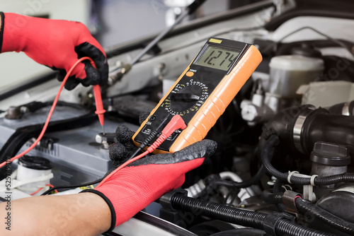 Auto mechanic Check batteries, repair, and replace engine parts. photo