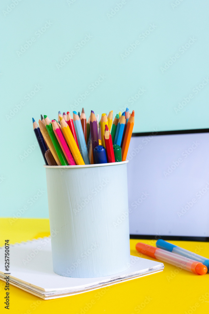 Fototapeta premium Tablet and notebook for online study on yellow and blue