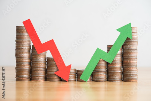 Stack coins and arrow red green graph chart volatility up and down on wooden table background. Business, financial and investment concept. Risk, fluctuation in stock market and cryptocurrency. photo