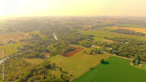 Top angle aerial view Drone shot of homes and farms in Ririe, Idaho with green trees and woods in a beautiful colorful orange sunset sun 4K UHD 3840