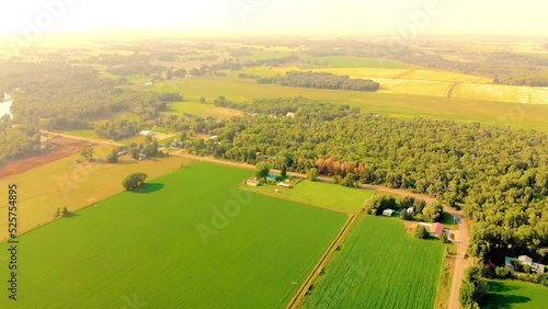 Top angle aerial view Drone shot of homes, cars, houses and farms in Ririe, Idaho with green trees and woods in a beautiful colorful orange sunset sun 4K UHD 3840