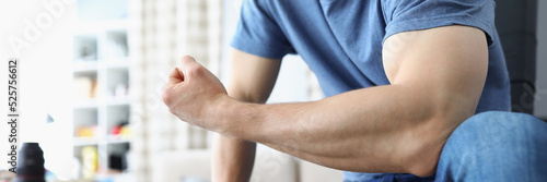 Man bending his arm and straining his biceps closeup