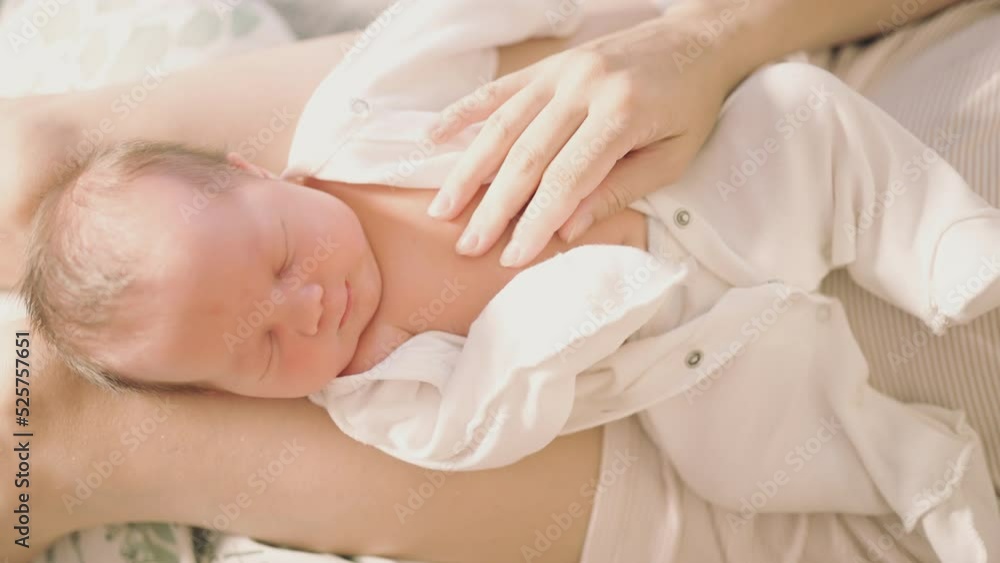 newborn baby close-up with mother's hand that gently touches the baby newborn baby close-up with mother's hand that gently touches the baby