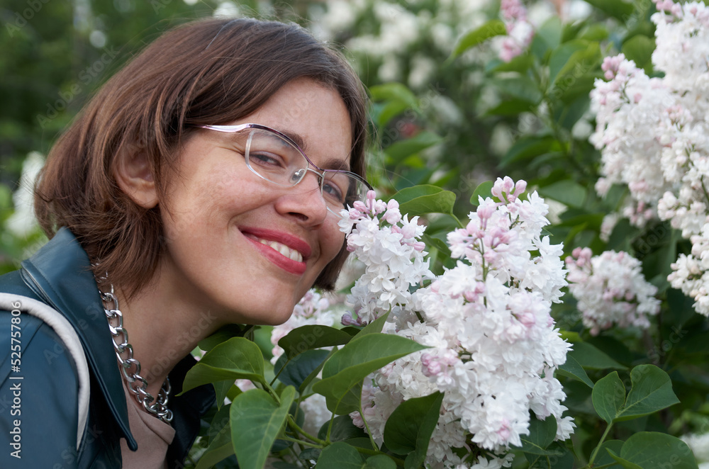 Close up portrait of beautiful smiling woman near white lilac Close up portrait of beautiful smiling woman near white lilac