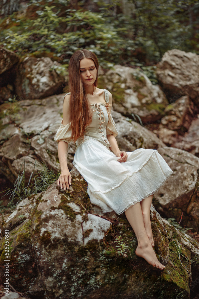 A girl in white sits on the waves in a wild forest. A girl in a corset sits on a stone in the forest. A girl in white sits on the waves in a wild forest. A girl in a corset sits on a stone in the forest.