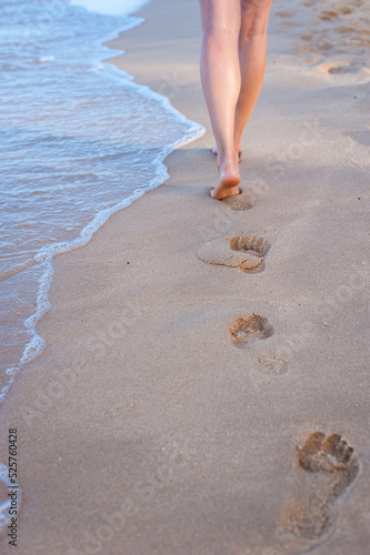 Woman walking barefoot on the beach