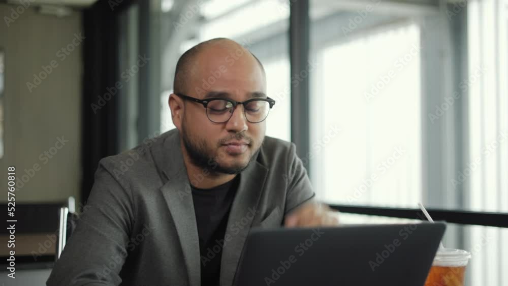 Handsome middle-aged businessman wearing gray suit sitting feeling stress from work desk in unhappy day. Man sitting in office and treat his head on hands cause he get hurt from headache in bad day. Handsome middle-aged businessman wearing gray suit sitting feeling stress from work desk in unhappy day. Man sitting in office and treat his head on hands cause he get hurt from headache in bad day.