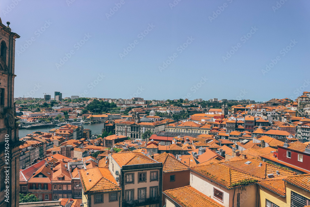 Orange roofs on high part of the city with different antique architecture and city in front