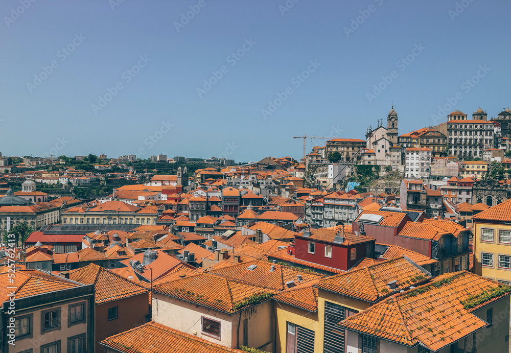 Orange roofs on high part of the city with different antique architecture and city in front