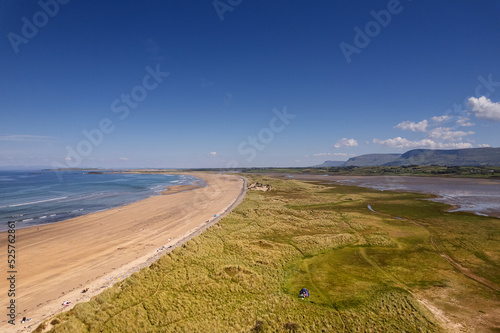 Aerial view on Streedagh beach in county Sligo, Ireland. Beautiful nature scene with warm yellow sand and blue ocean and clear blue sky. Popular tourist area. Warm sunny day. photo