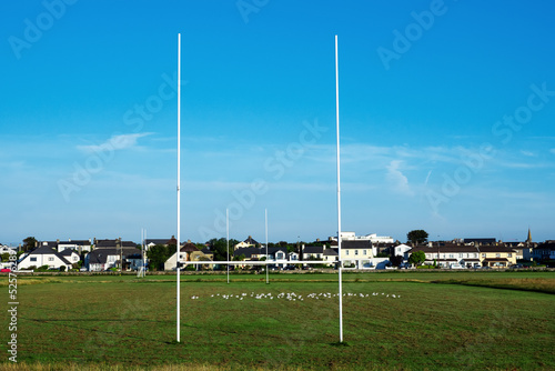 Green grass in a field and tall goal posts for Irish National sports in a field of the South park, Galway city, Ireland. Rugby, hurling, camogie and Gaelic football training ground. Nobody.