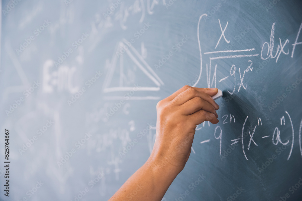 Fototapeta premium Teacher or student writing on blackboard during math lesson in school classroom