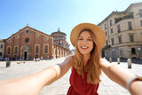 Beautiful fashion girl takes self portrait with the church of Santa Maria delle Grazie which preserves 