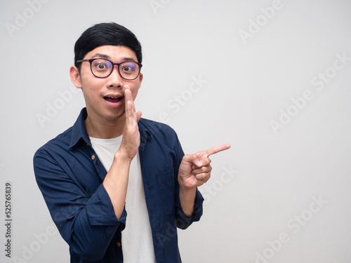 Glasses man gesture whister to you and point finger at copy space