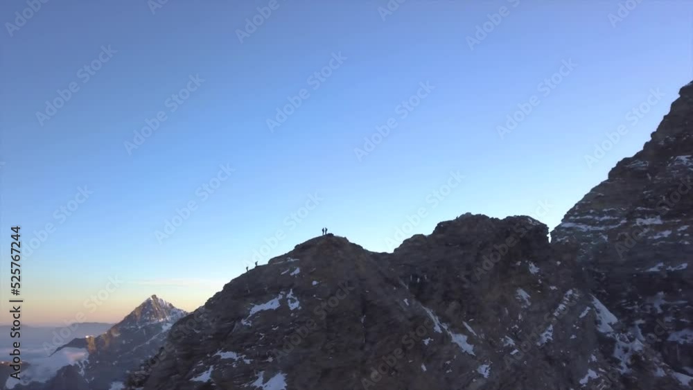 Aerial view from drone of climbers ascending Lion Ridge of Mount Cervino toward the peak known as Matterhorn at sunrise. Extreme conditions, altitude and cold. Dangerous adventure. Mountain climbing. Aerial view from drone of climbers ascending Lion Ridge of Mount Cervino toward the peak known as Matterhorn at sunrise. Extreme conditions, altitude and cold. Dangerous adventure. Mountain climbing.