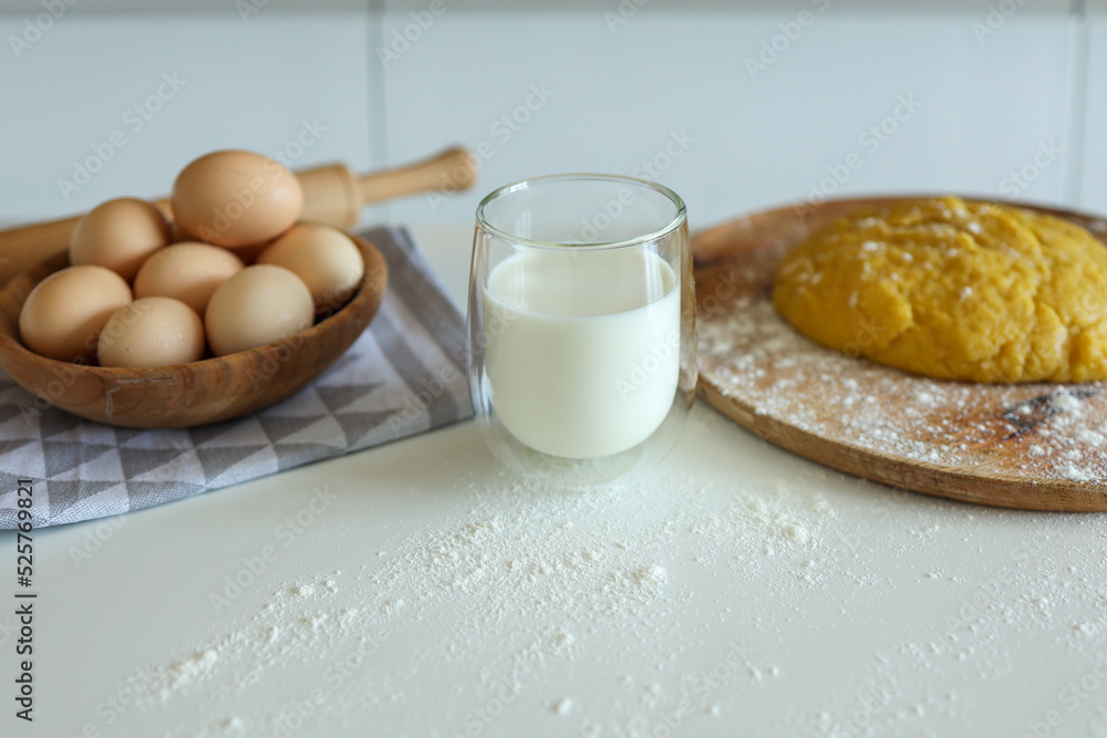 Baking ingredients placed on white table, ready for cooking. Concept of food preparation Baking ingredients placed on white table, ready for cooking. Concept of food preparation