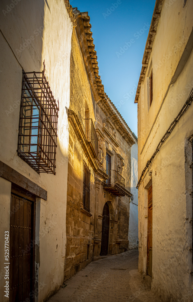Narrow alley in the old town of Úbeda, Jaen, Andalusia, Spain. Lit up at sunset with Renaissance palace to one side