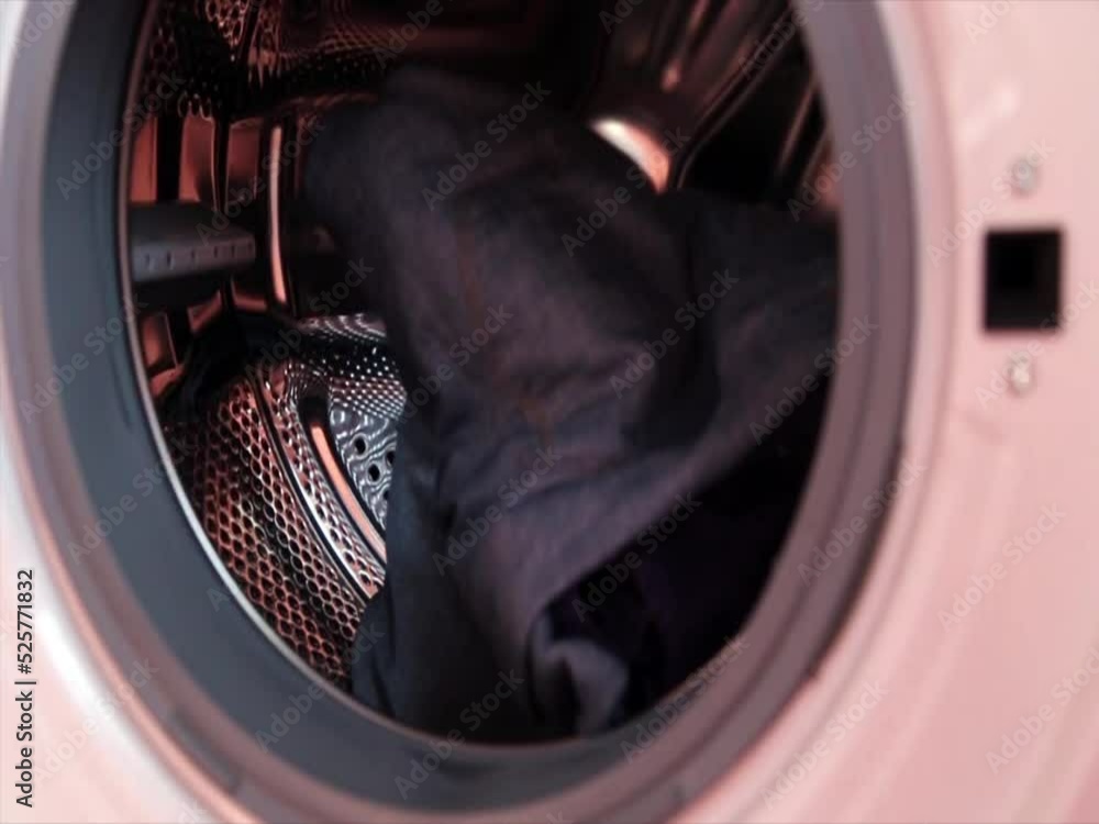 Close Up Of Men Loading Dirty Clothes Into Washing Machine Close Up Of Men Loading Dirty Clothes Into Washing Machine