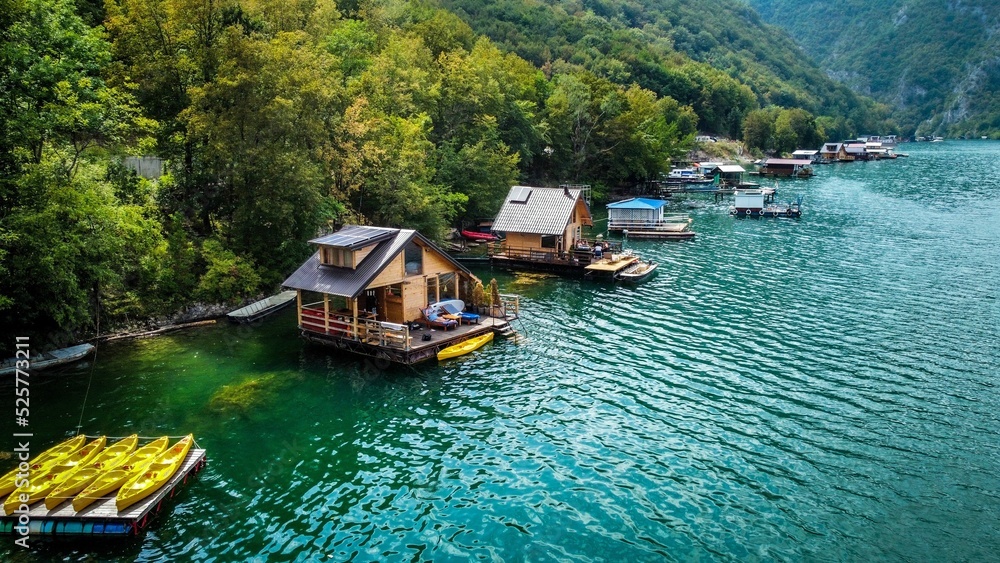 Naklejka premium Raft house on an artificial lake. Big water surface and houses on a lake. Holiday house on water. High contrast and saturation