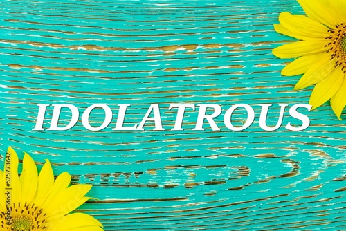 IDOLATROUS - text, yellow flowers, sunflowers, wooden background (copy space). photo