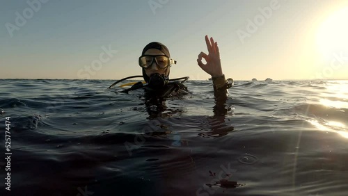 Dver shows OK sign on the sea surface after diving. Red sea, Egypt. photo