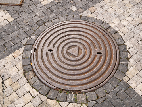 Metal hatch on paving stones.