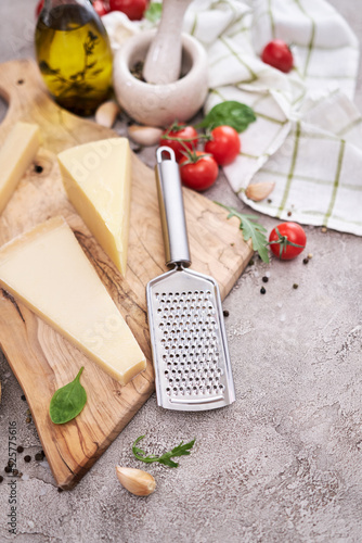 Parmesan cheese and grater on a wooden cutting board