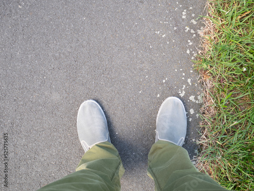 Feet on the asphalt road in the city.
